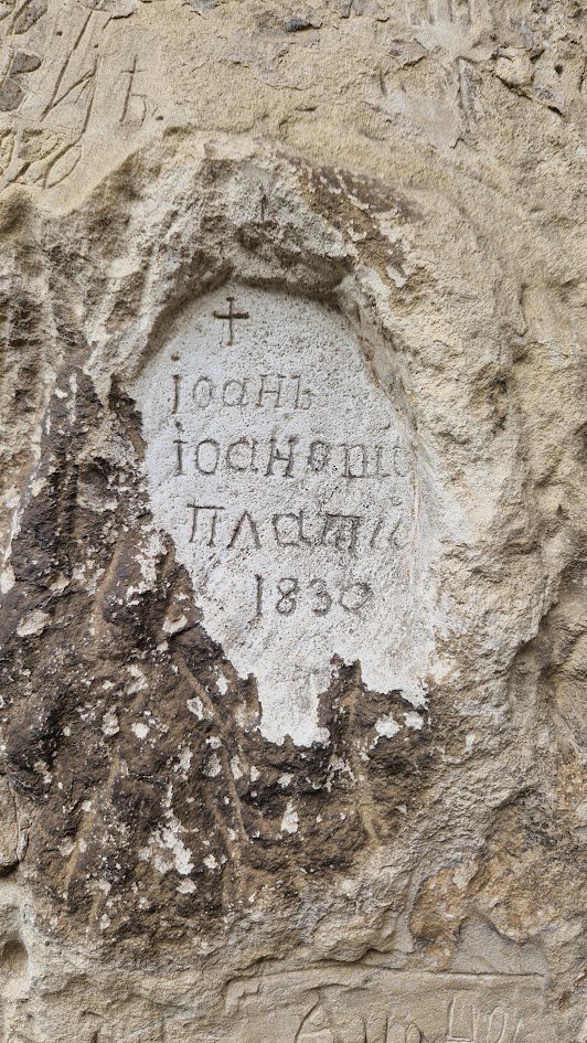 An inscription of 1830 in its own carved niche, with a cross above