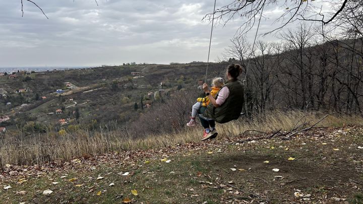 Auf der Schaukel am Aussichtspunkt über Novi Rakovac im Spätherbst, am Horizont Novi Sad