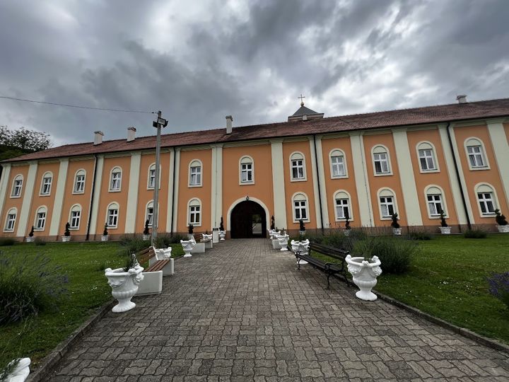 Der Weg zum Klostertor zwischen Lavendelbeeten, Bänken und weißen Steinvasen