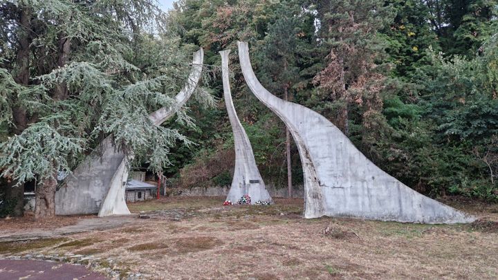 Die Gedenkstätte Stručica: drei geschwungene Betonpfeiler zwischen den Bäumen