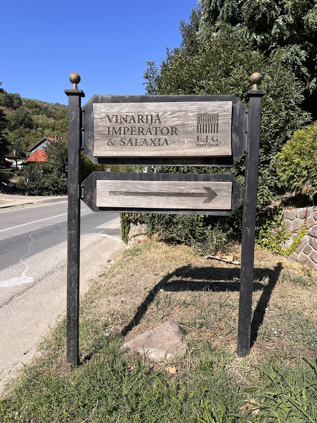 Wooden roadside sign: “Vinarija Imperator & Salaxia” and “Fig restoran”, with an arrow